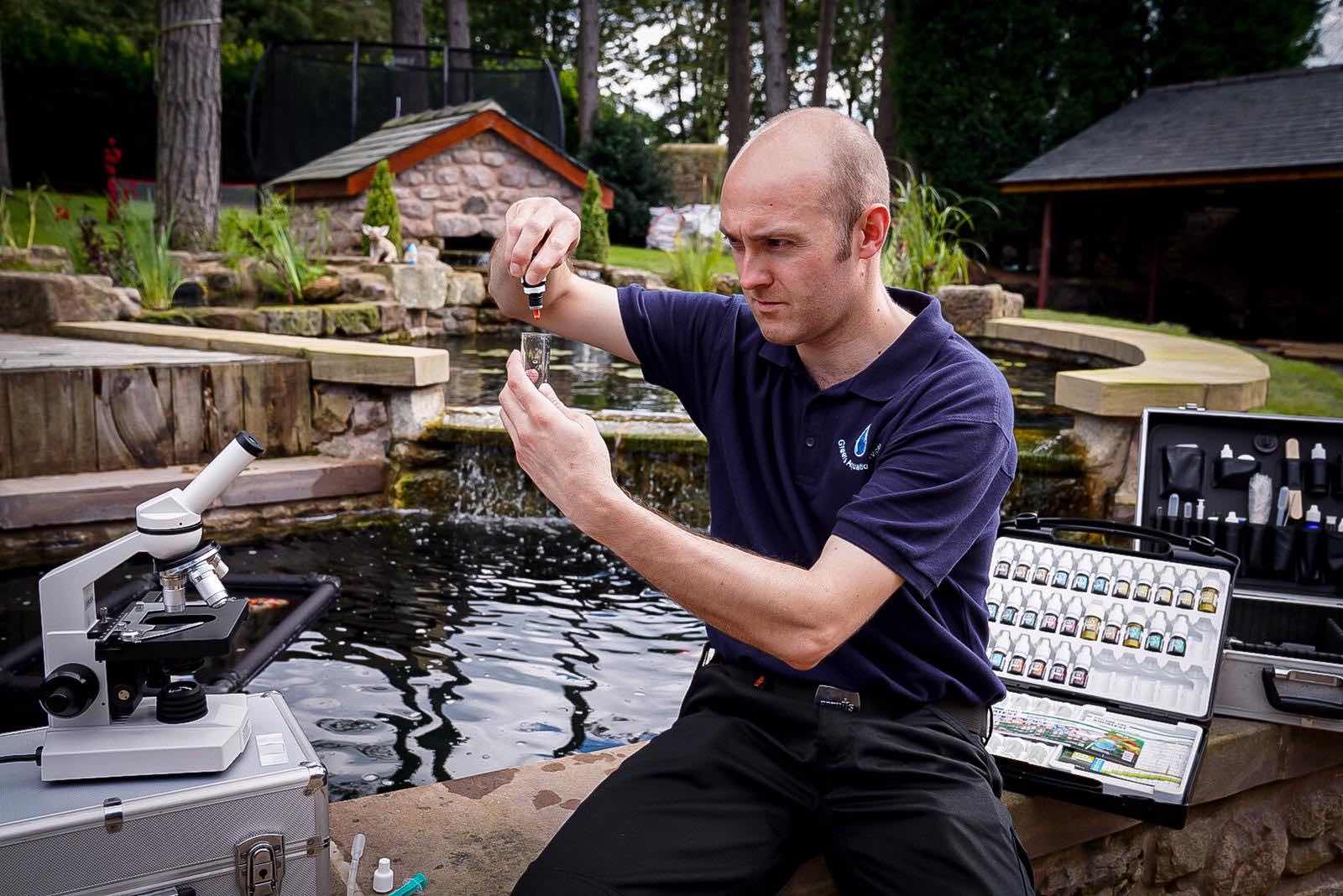 Pond expert testing the pH of a pond, as part of a pond water quality testing service in Chorley.
